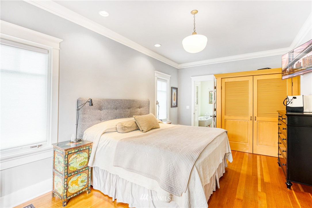 415 5th Street Anacortes, WA 98221 - Photo 13 of 38 a bedroom with a bed and a chandelier