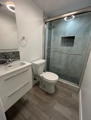 a bathroom with a toilet a sink and shower