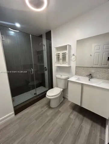 a bathroom with a sink mirror toilet and shower