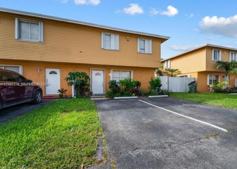 35 Northeast 12th Avenue, Unit 35 Homestead, FL 33030 - Photo 2 of 22 a front view of a house with a yard and garage