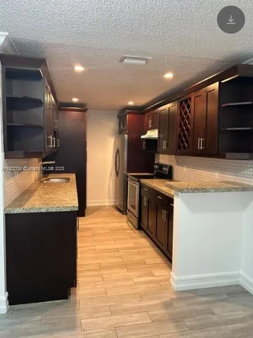 a kitchen with stainless steel appliances granite countertop a sink and a stove