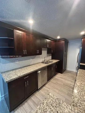 a large kitchen with kitchen island a sink stainless steel appliances and cabinets