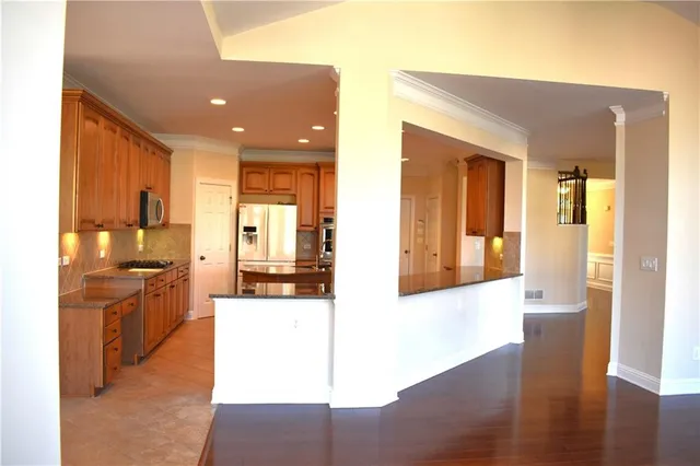 a kitchen with stainless steel appliances granite countertop a refrigerator a stove top oven a sink and dishwasher