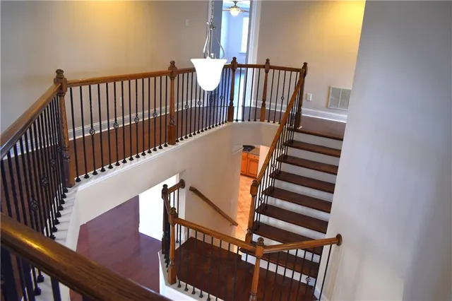 a view of staircase with railing and a window