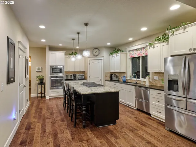 a kitchen with stainless steel appliances granite countertop a refrigerator sink and cabinets