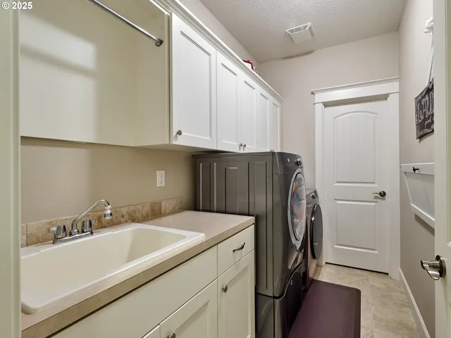 a view of an house with backyard and a tree