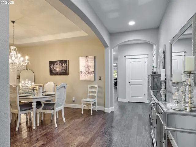 a dining room with furniture a chandelier and wooden floor
