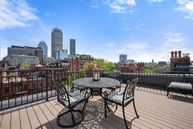 a view of a roof deck with couches and potted plants