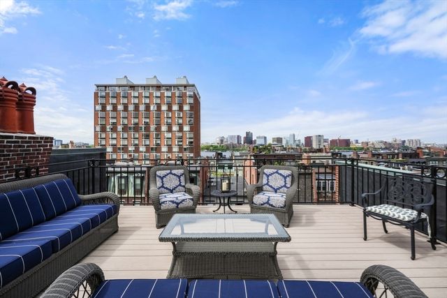 a view of a roof deck with couches table and chairs