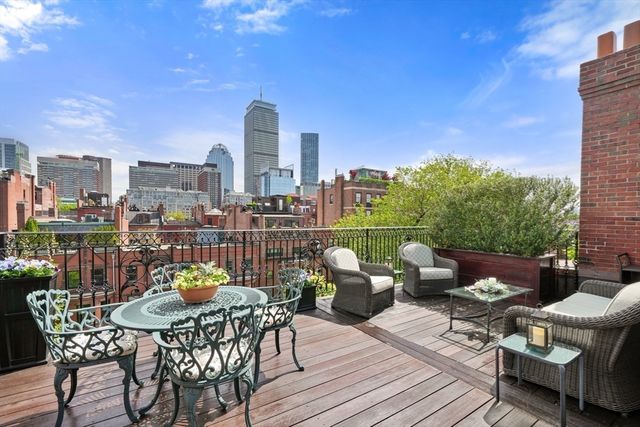 a view of a roof deck with furniture