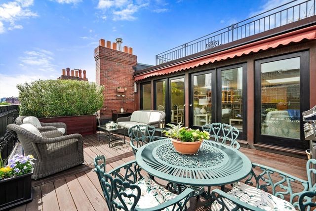 a balcony with furniture and a potted plant