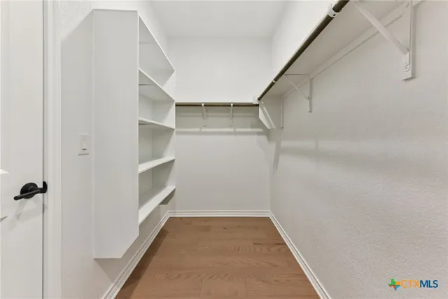 a view of walk in closet with empty racks