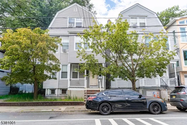 a car parked in front of a white house