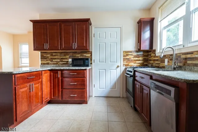 a kitchen with stainless steel appliances granite countertop wooden cabinets a sink and a stove