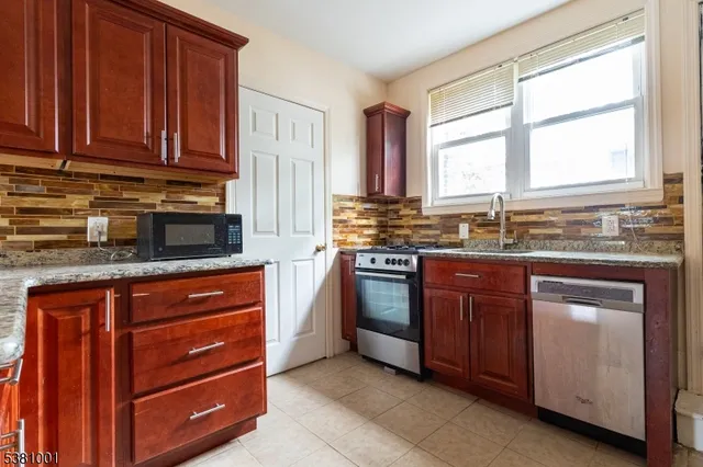 a kitchen with stainless steel appliances granite countertop a stove sink and microwave