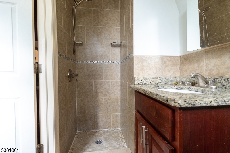 873 South 19th Street, Unit 3 Newark, NJ 07108 - Photo 6 of 10 a bathroom with a granite countertop sink and shower