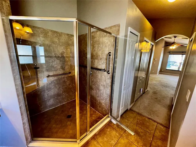 a bathroom with a glass shower door and mirror
