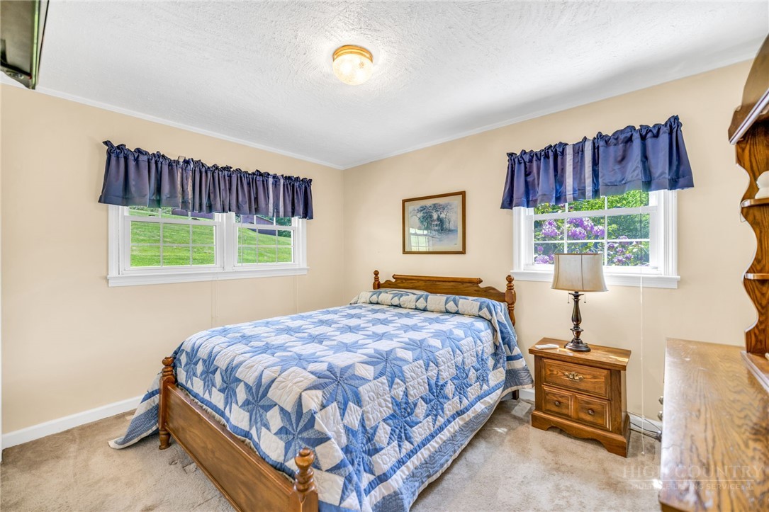 346 Piney Creek Road Lansing, NC 28643 - Photo 20 of 24 a bedroom with a bed a dresser and a window