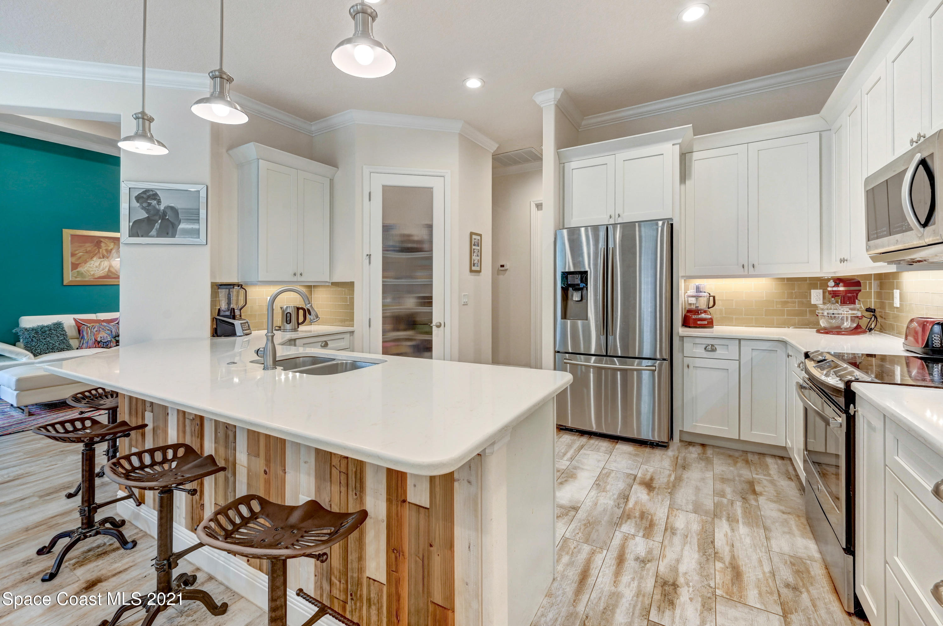 4108 Anlow Road Melbourne, FL 32904 - Photo 40 of 56 a kitchen with stainless steel appliances a stove a refrigerator a sink a dining table and chairs