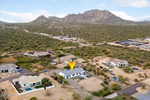 a front view of a house with a yard and mountain view in back