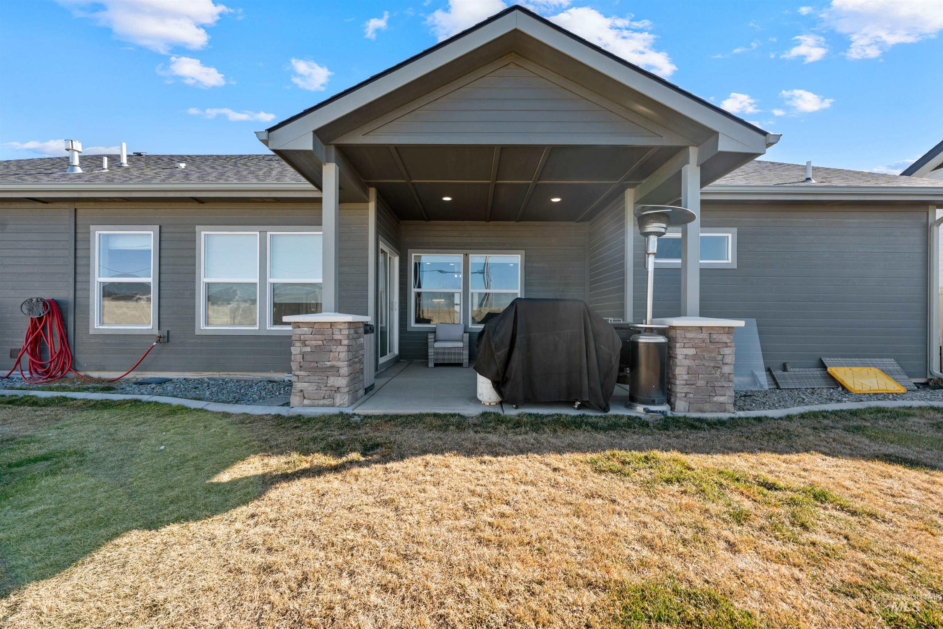 1005 Kenbrook Loop Twin Falls, ID 83301 - Photo 35 of 47 Back of property featuring a patio area, a lawn, and roof with shingles