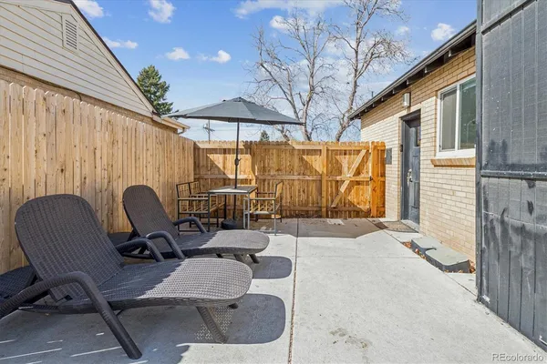 a view of a patio with a table and chairs and a barbeque