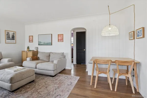 a living room with furniture and a wooden floor