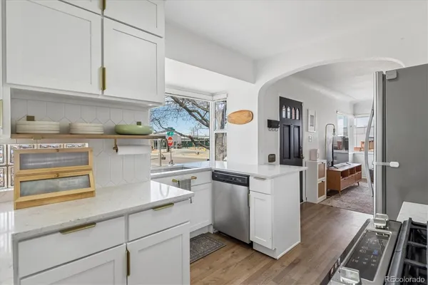 a kitchen with white cabinets and refrigerator