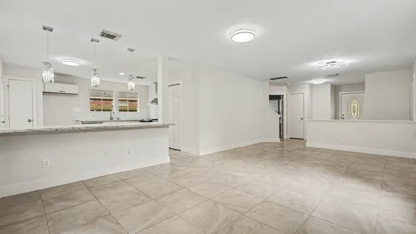 a view of kitchen with kitchen island white cabinets and refrigerator