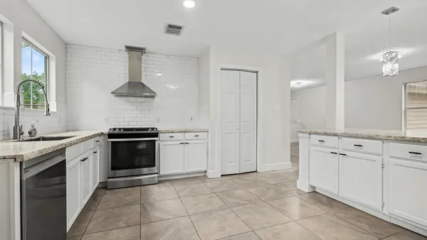 a kitchen with stainless steel appliances a sink stove and cabinets