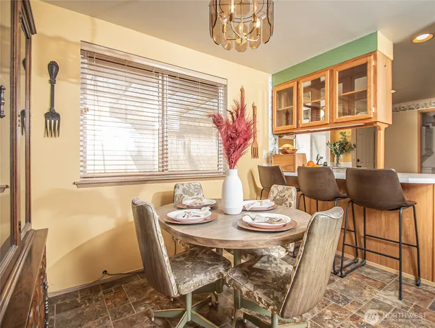 a view of a dining room with furniture a chandelier and wooden floor