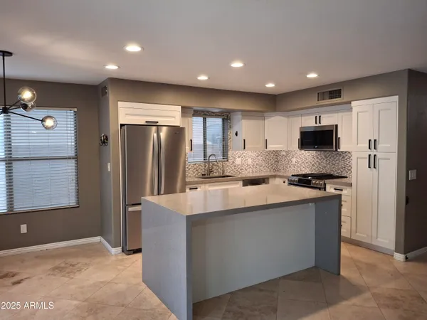 a kitchen with stainless steel appliances granite countertop a refrigerator stove and oven