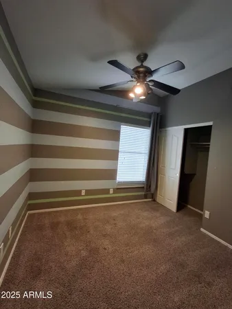 en empty room with windows and fan