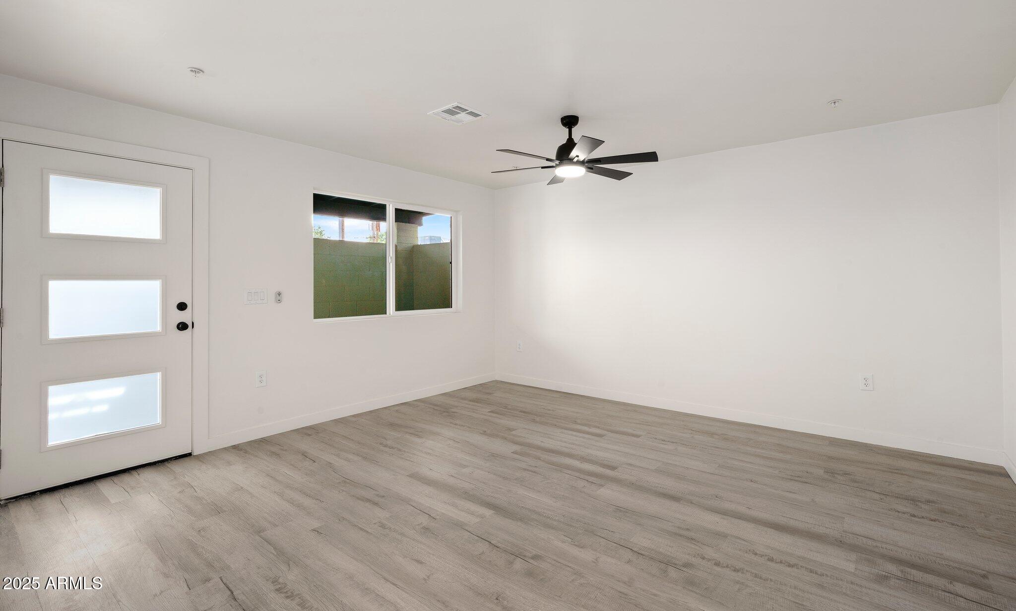 3114 North 68th Street, Unit 3 Scottsdale, AZ 85251 - Photo 25 of 25 an empty room with wooden floor and windows