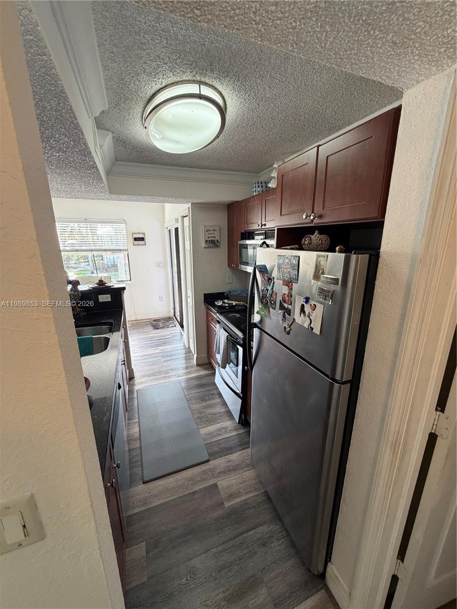 10670 Southwest 156th Place, Unit 308 Miami, FL 33196 - Photo 17 of 21 a kitchen with stainless steel appliances granite countertop a refrigerator a stove a sink and dishwasher