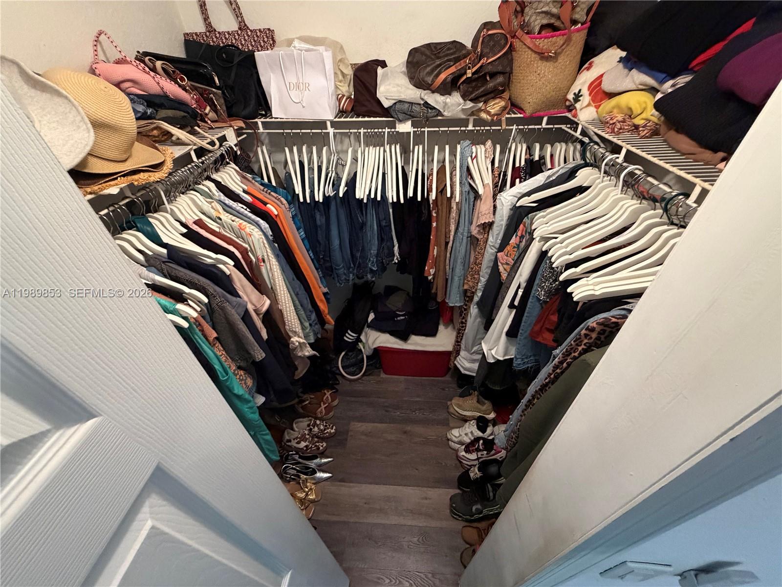 10670 Southwest 156th Place, Unit 308 Miami, FL 33196 - Photo 20 of 21 a view of walk in closet with clothes and shoes