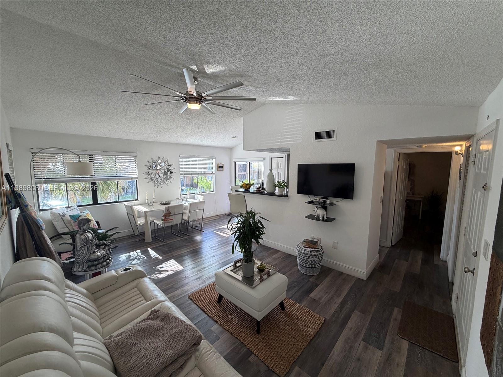 10670 Southwest 156th Place, Unit 308 Miami, FL 33196 - Photo 2 of 21 a living room with furniture a flat screen tv and a view of kitchen