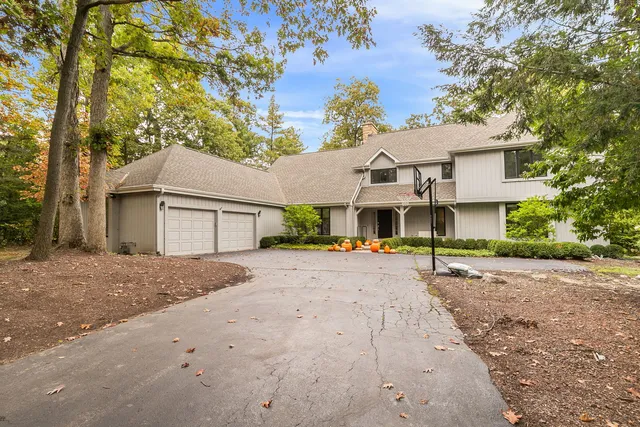 a view of a house with a yard and large tree