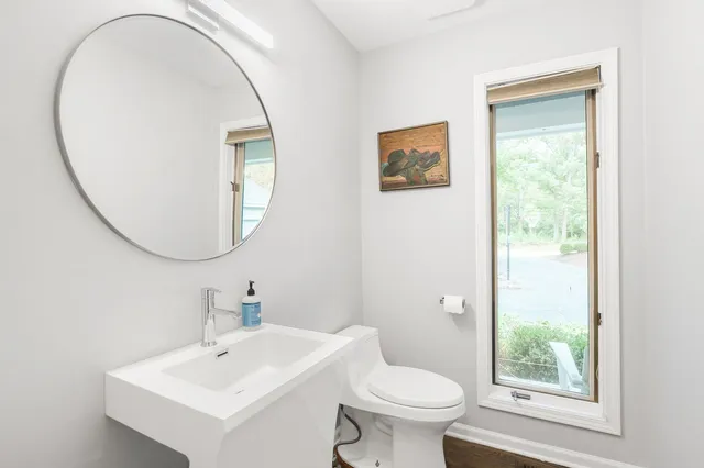 a bathroom with a toilet a sink and a mirror