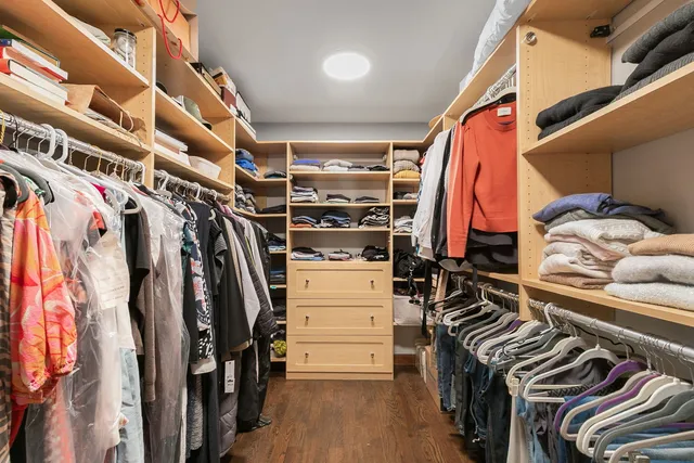 a view of walk in closet with clothes and shoes