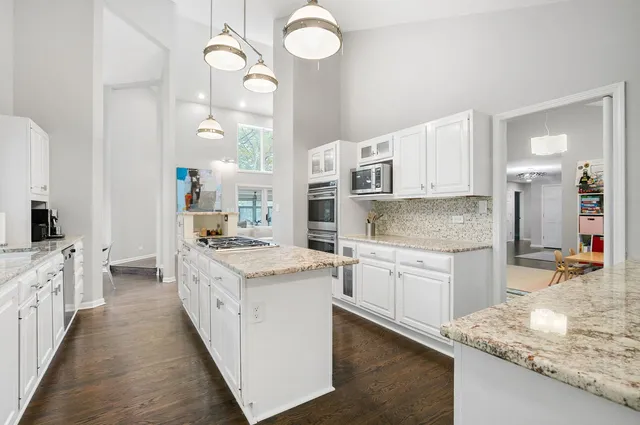 a kitchen with granite countertop a sink stove top oven and cabinets