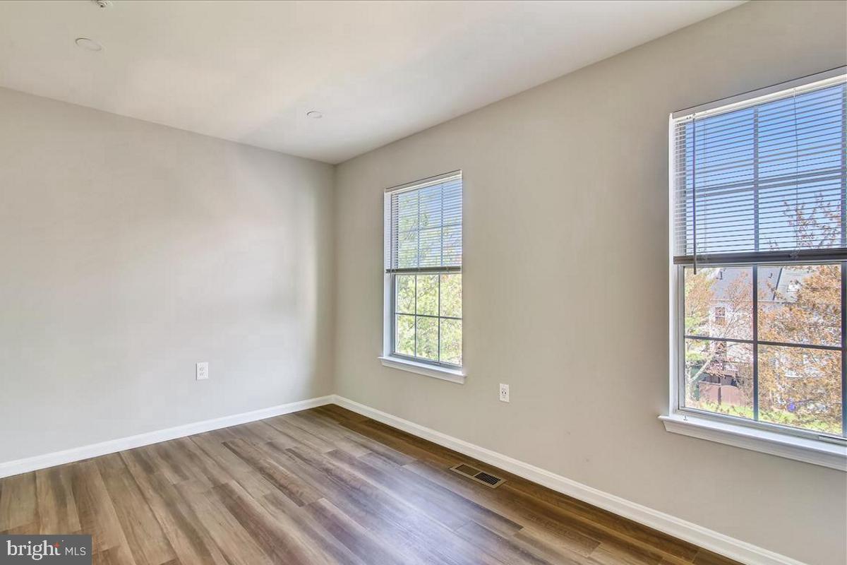106 Princetown Drive, Unit 5B Frederick, MD 21702 - Photo 11 of 38 an empty room with wooden floor and windows