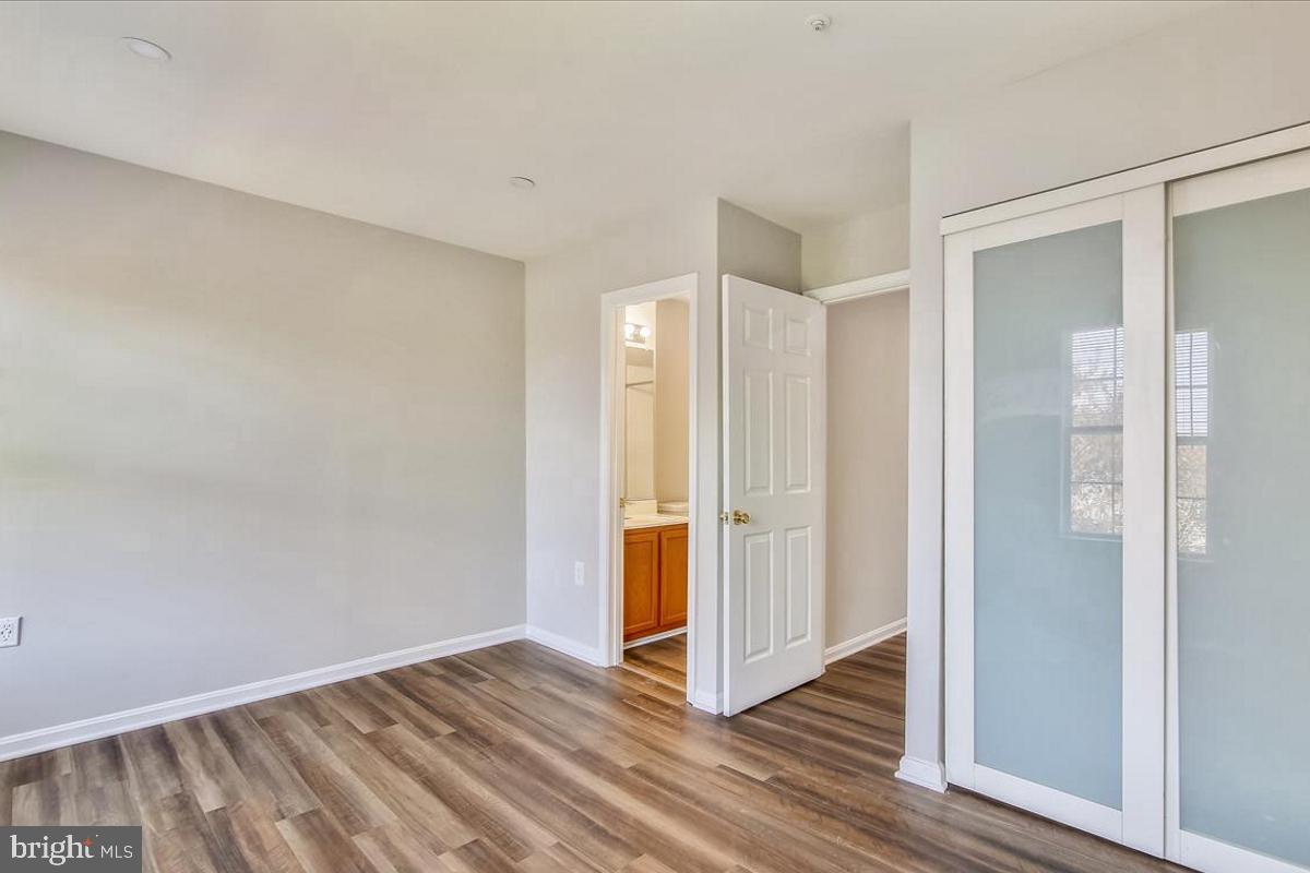 106 Princetown Drive, Unit 5B Frederick, MD 21702 - Photo 12 of 38 a view of an empty room with wooden floor and a bathroom