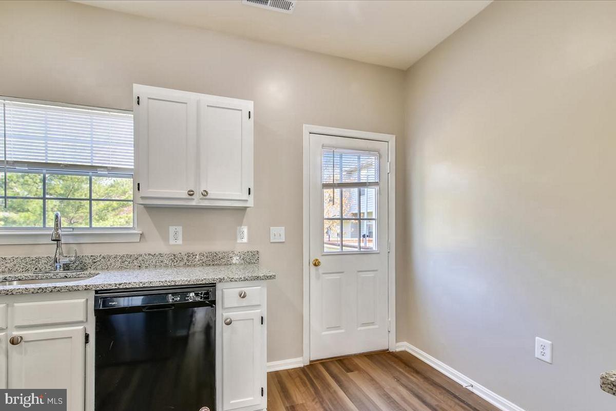 106 Princetown Drive, Unit 5B Frederick, MD 21702 - Photo 6 of 38 a kitchen with granite countertop white cabinets and white appliances