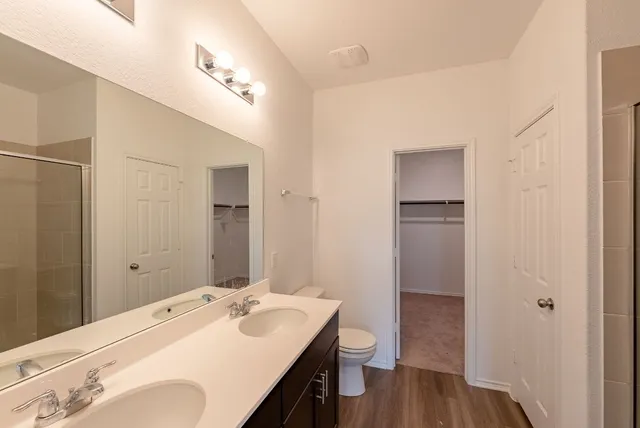 a view of an empty room with wooden floor and windows