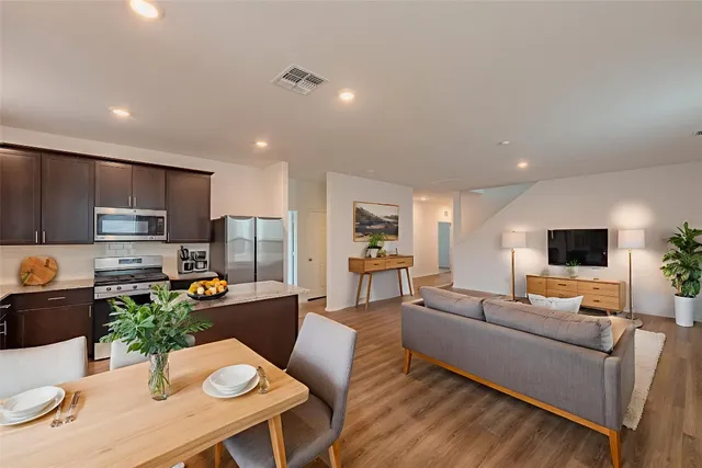a living room with furniture a flat screen tv and kitchen view