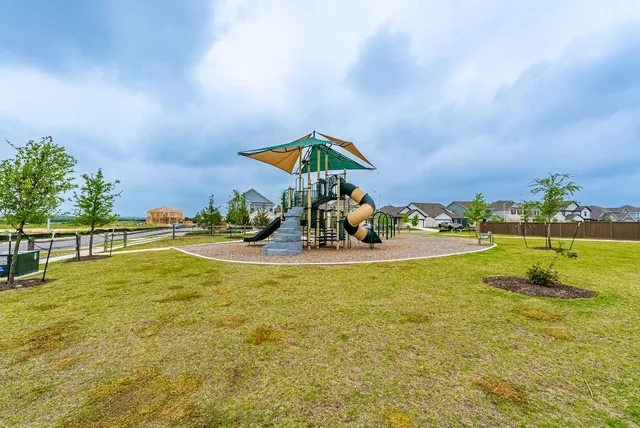 a big house with a yard and wooden fence