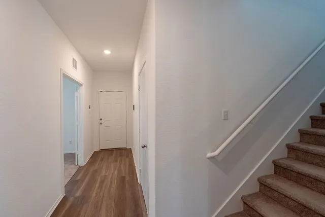 a view of a hallway with wooden floor and entryway