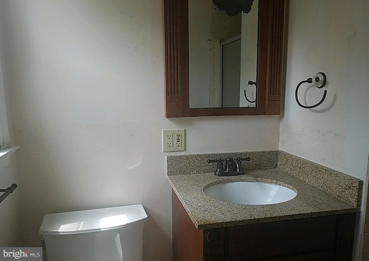 4618 Ballygar Road Baltimore, MD 21236 - Photo 21 of 29 a bathroom with a granite countertop sink a toilet and mirror