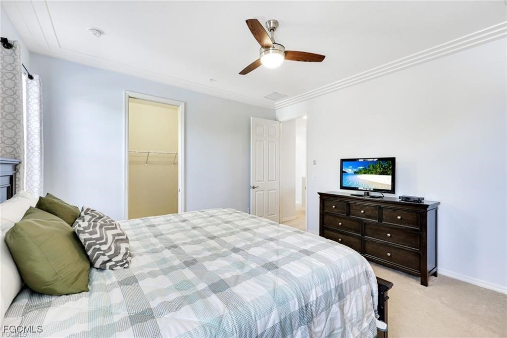 11758 Izarra Way, Unit 7703 Fort Myers, FL 33912 - Photo 11 of 37 a bedroom with a bed and a tv